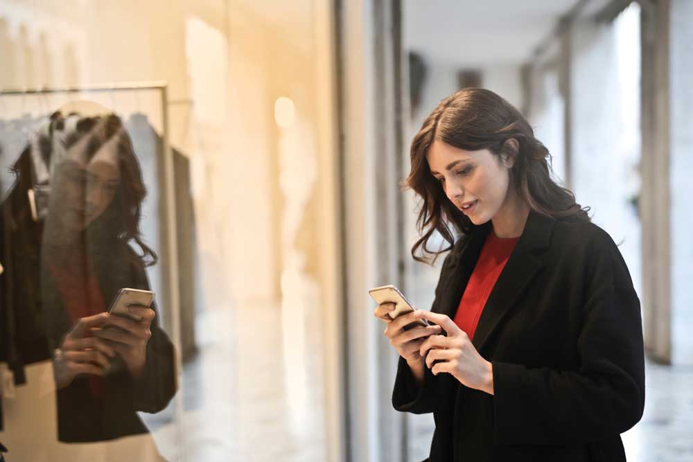 Woman Using Mobile to Browse While Shopping showing omnichannel retail customer experience and omnichannel vs. multi-channel