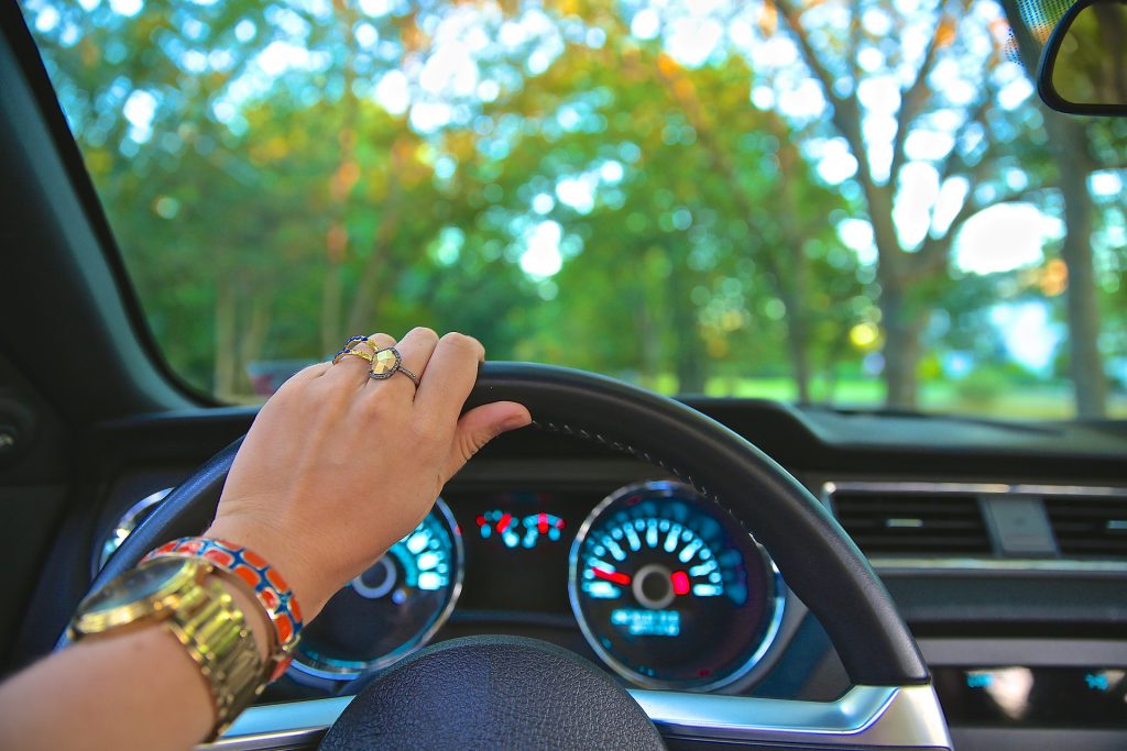 woman with hand on car steering wheel